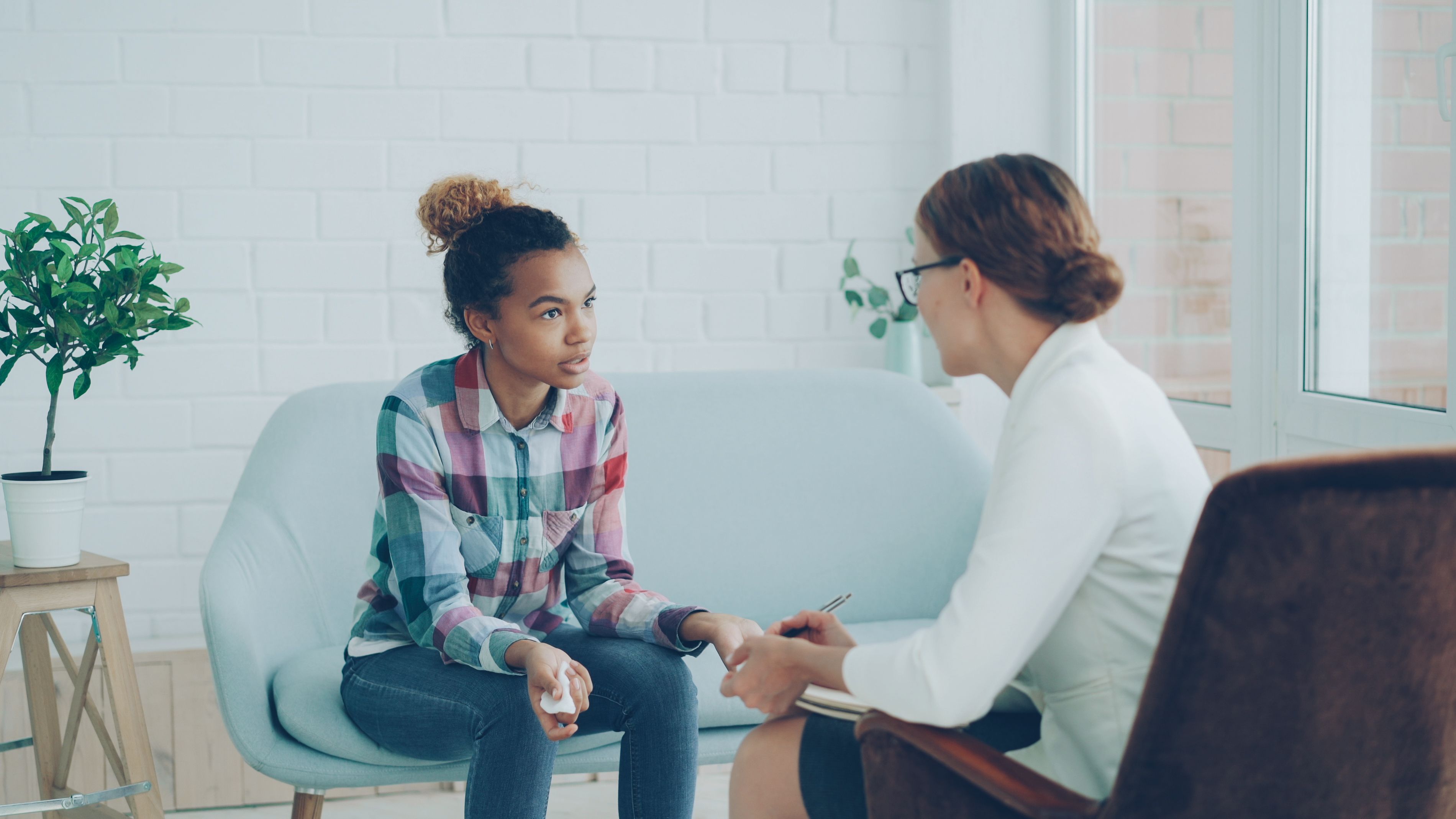 Teenage student talking with a therapist during a counseling session for support and reassurance